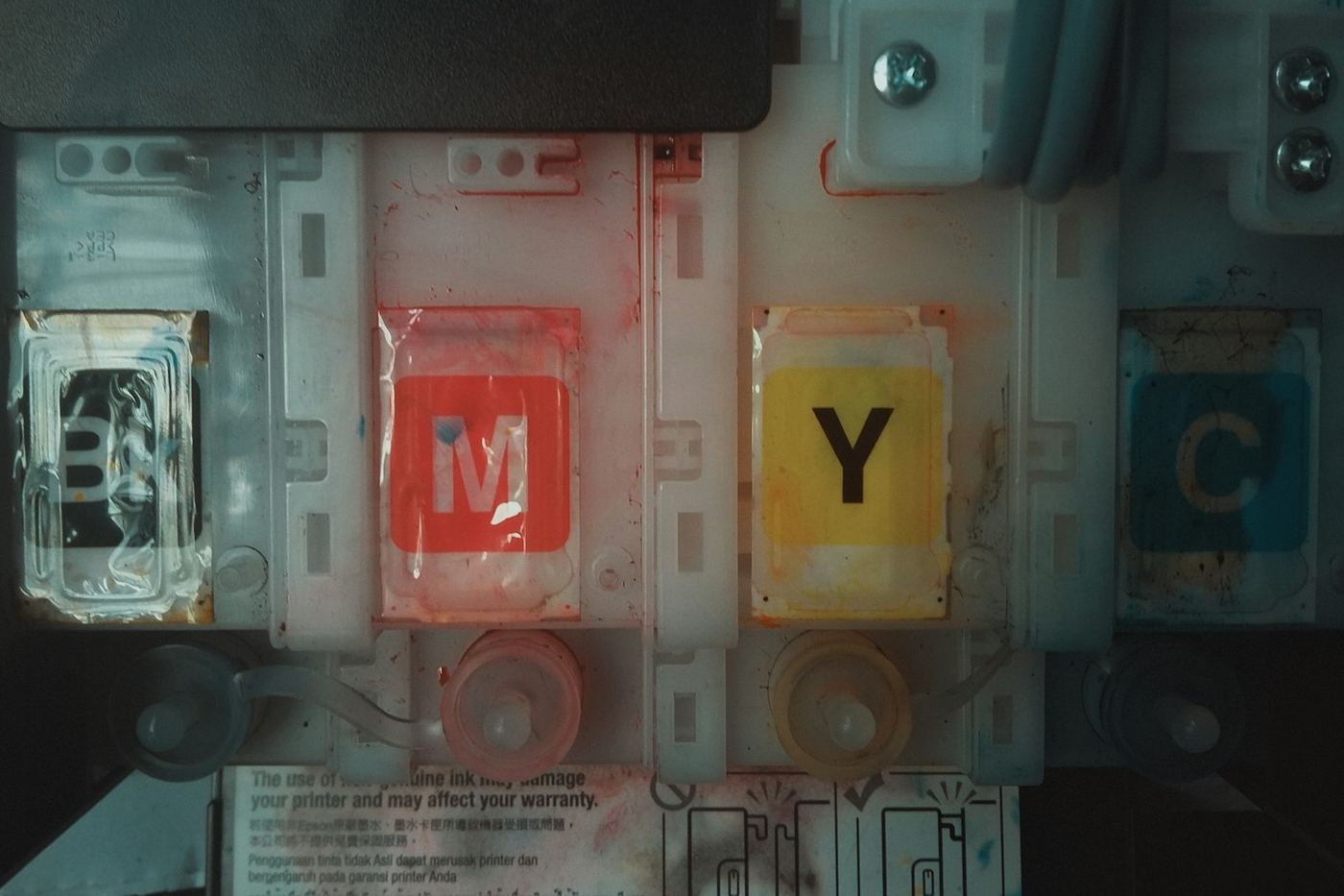 Magenta, yellow and cyan ink tanks inside a printer