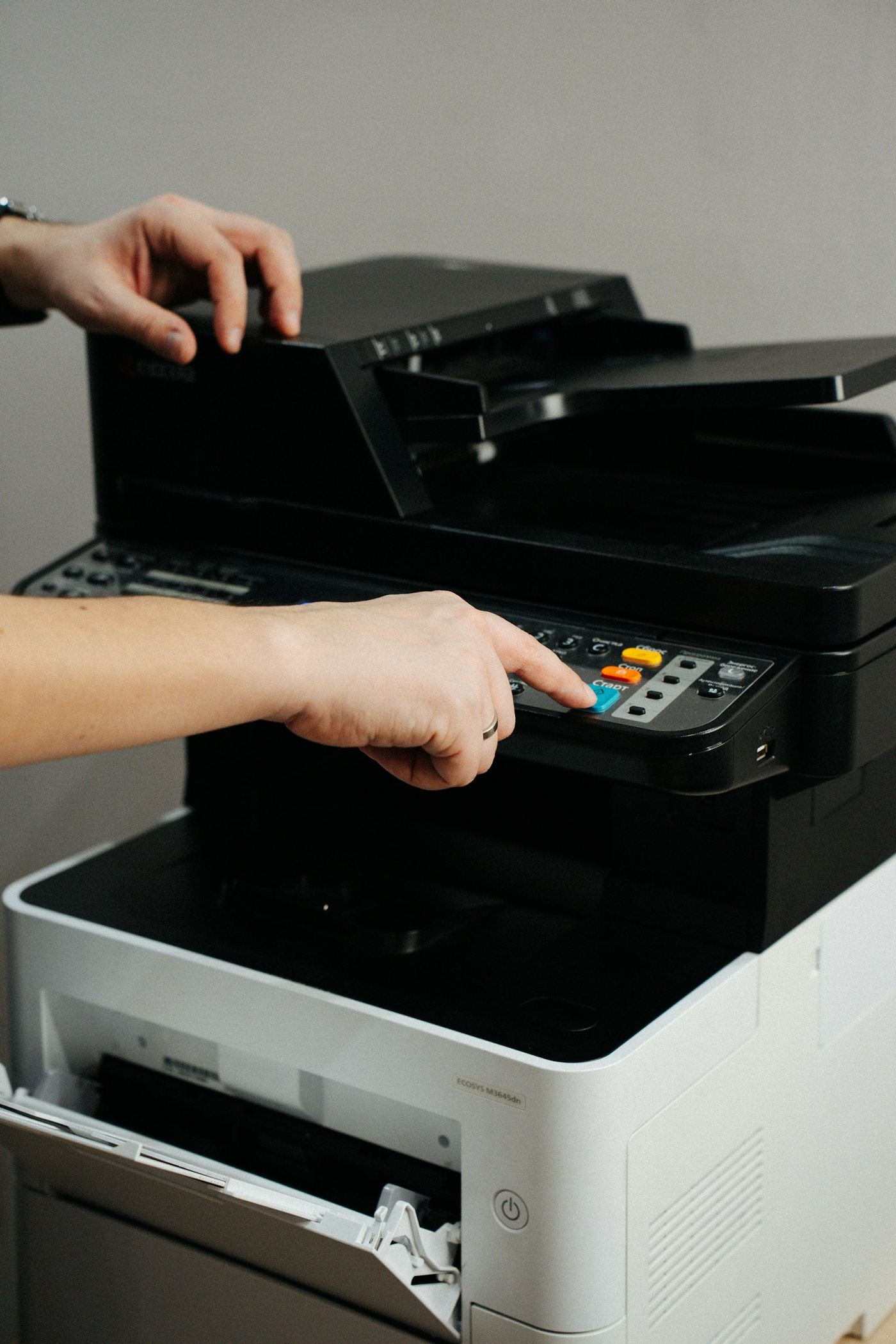 Hands using an office printer control panel